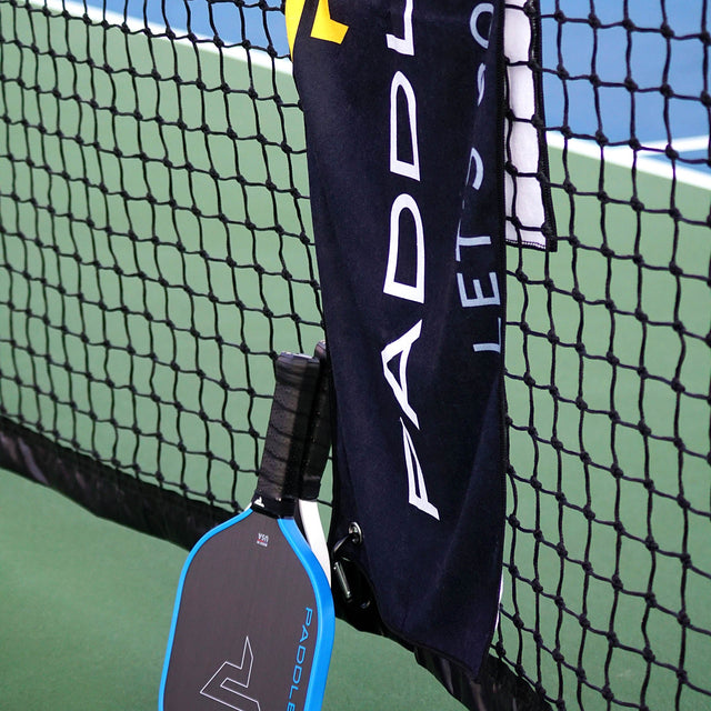 Paddletek Performance Towel hanging on a pickleball net