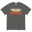 Pepper Bad Words Pickleball Tee in a textured flat lay, with cream PICKLEBALL lettering and rust BAD WORDS lettering.