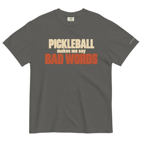 Pepper Bad Words Pickleball Tee in a textured flat lay, with cream PICKLEBALL lettering and rust BAD WORDS lettering.