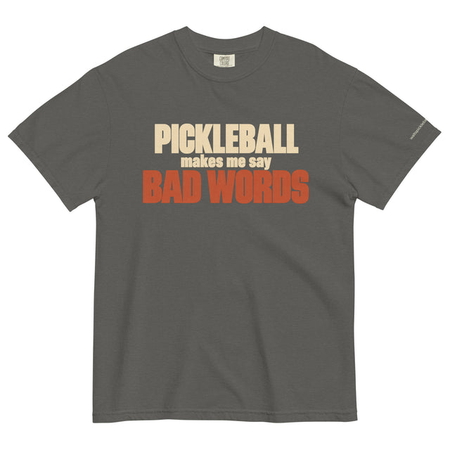 Pepper Bad Words Pickleball Tee in a textured flat lay, with cream PICKLEBALL lettering and rust BAD WORDS lettering.