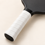 Illustrative paddle mockup showing a white WPS overgrip wrapped around the handle; paddle not included